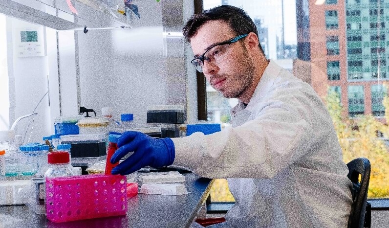 A scientist handling test tubes